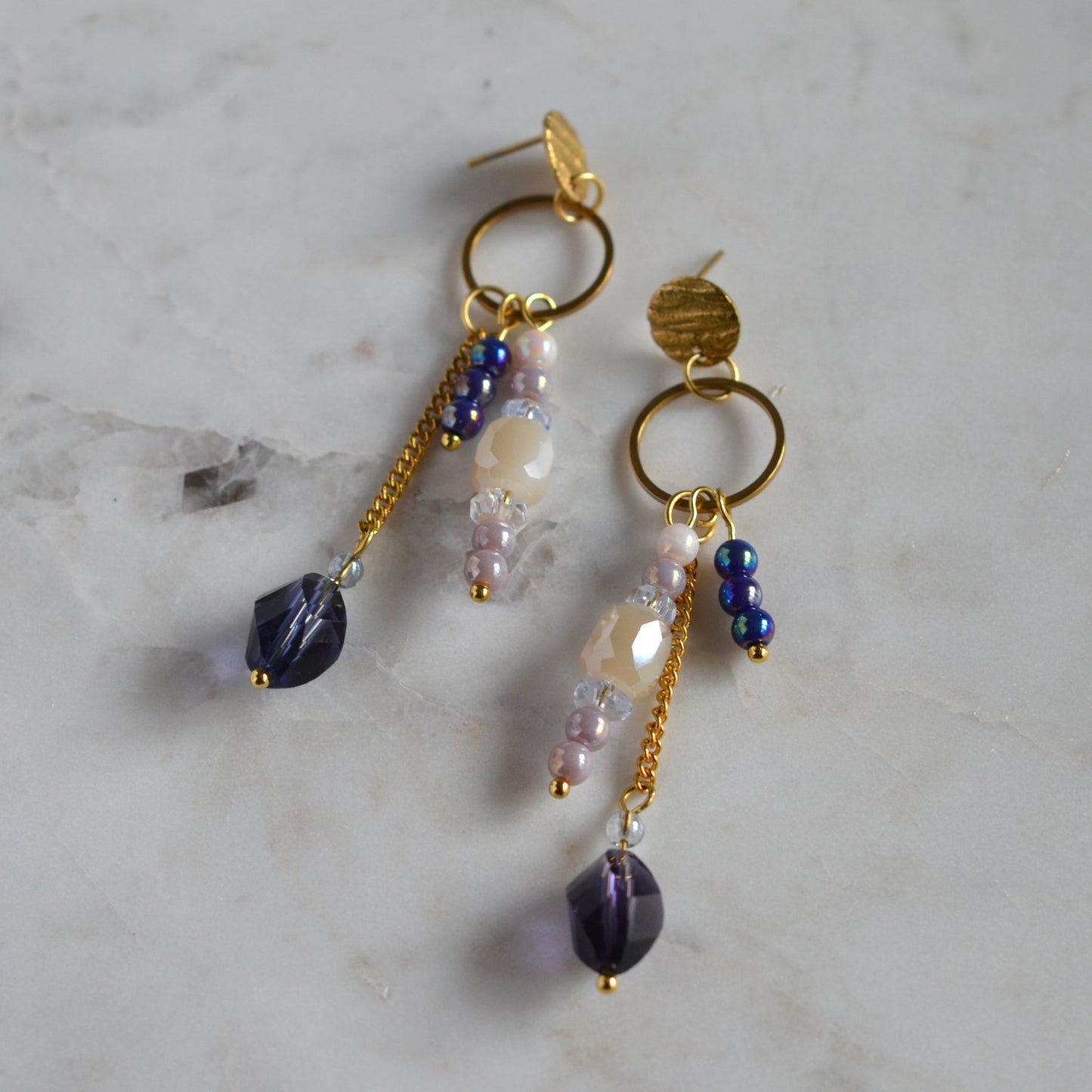 Goudkleurige oorbellen met paarse, lila en beige kralen