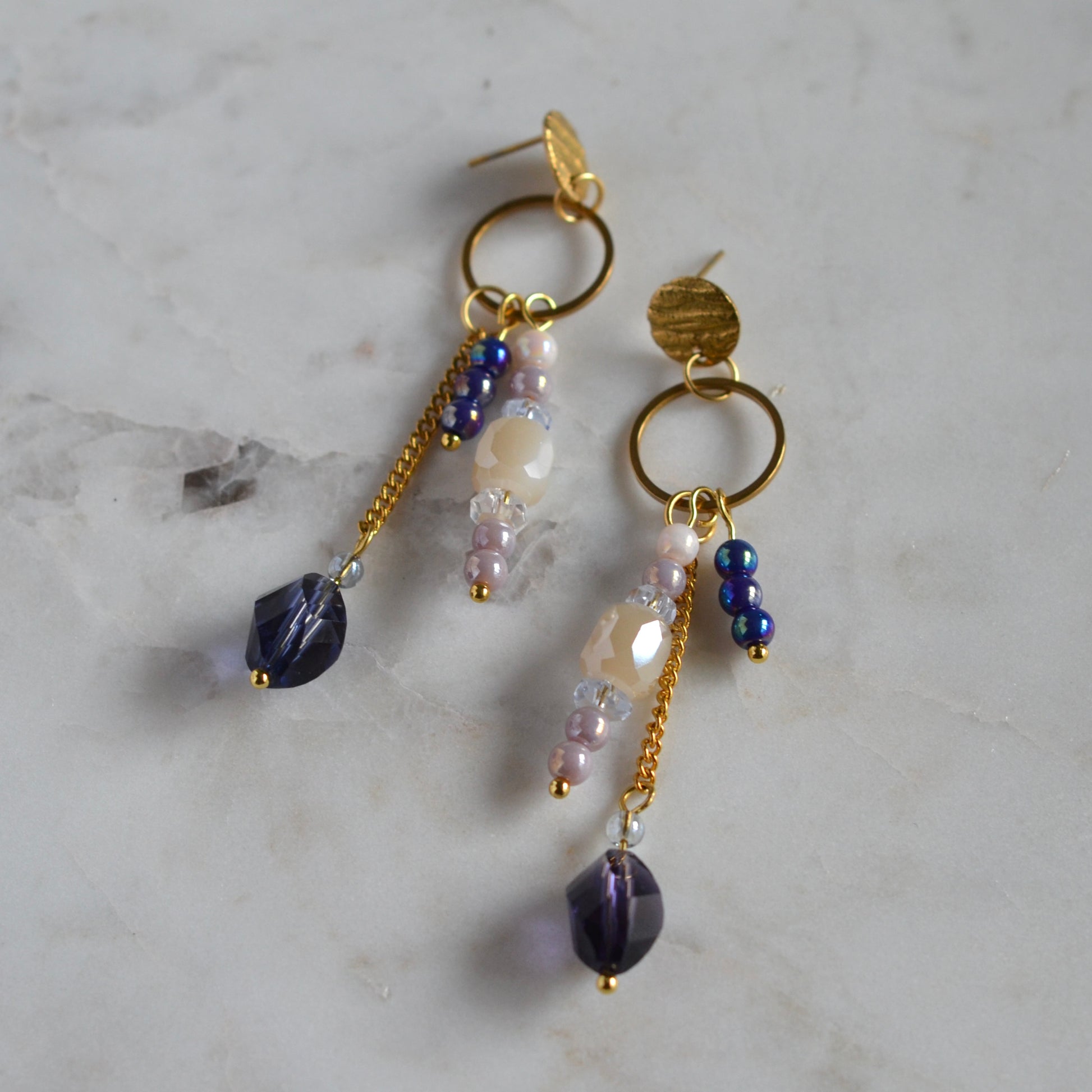 Goudkleurige oorbellen met paarse, lila en beige kralen