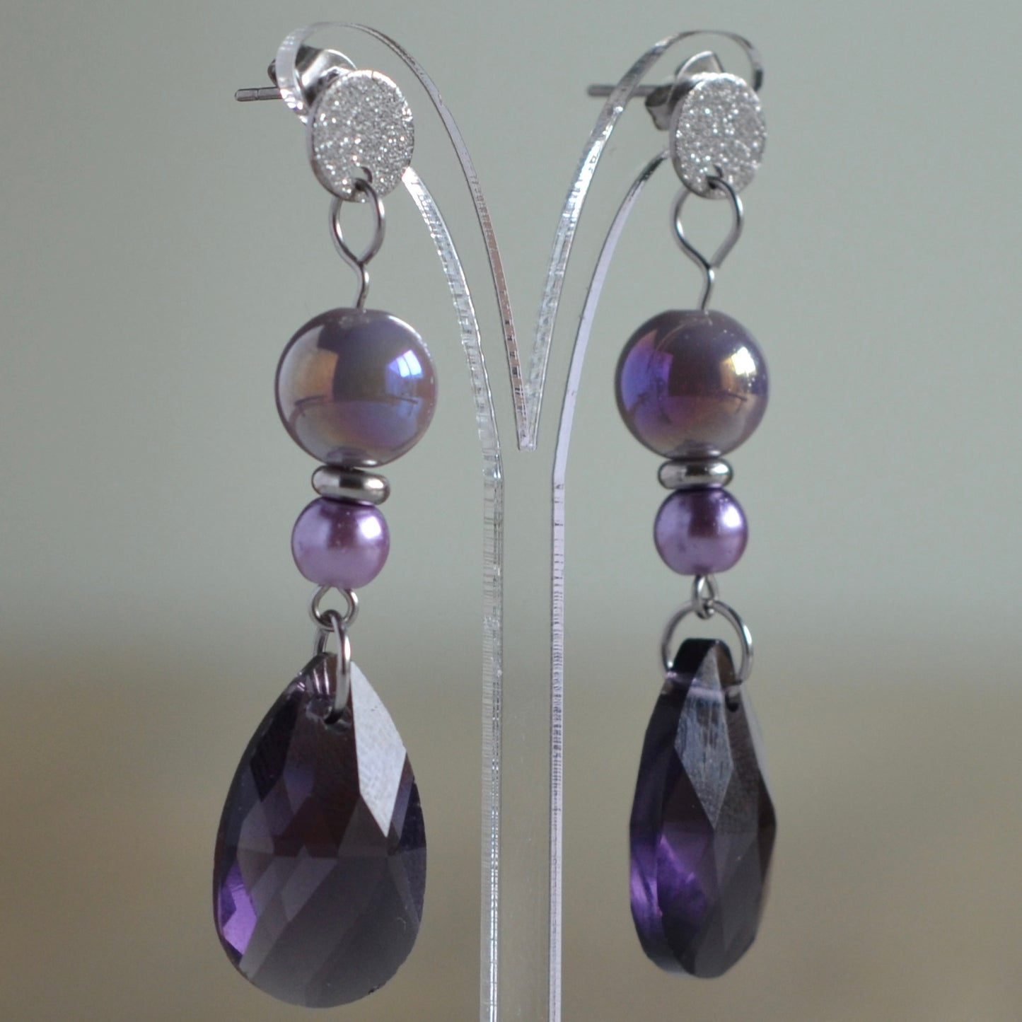 Zilverkleurige oorbellen met iriserende paarse kralen en facetgeslepen druppel